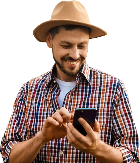 Imagem de uma pessoa com um chapéu, camisa xadrez e um celular na mão.