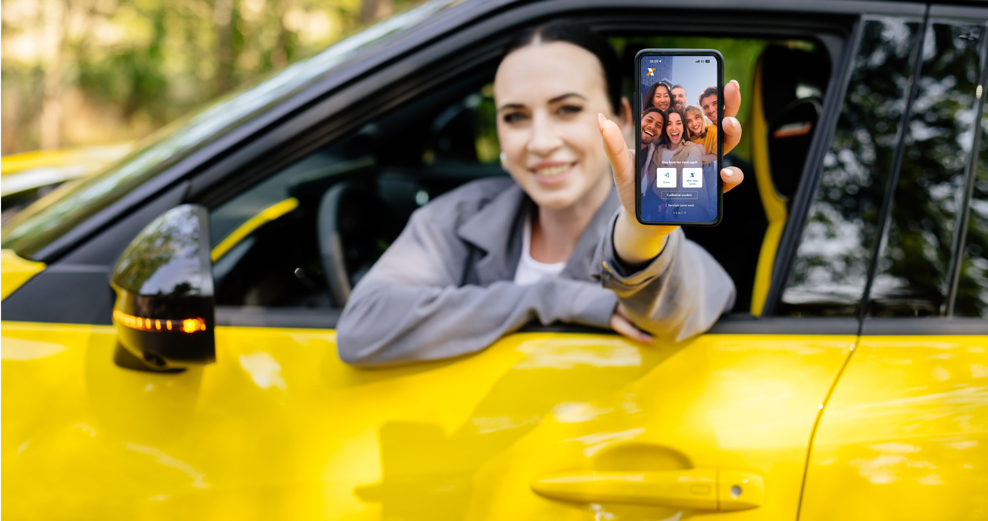 Homem sorrindo com um celular em uma ambiente externo