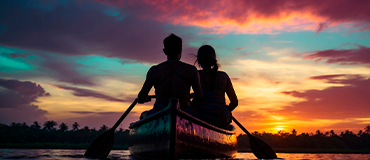 Duas pessoas remando em uma canoa durante um pôr do sol colorido.