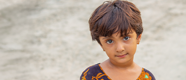 Criança usando roupa estampada em um ambiente externo.