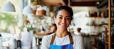 Pessoa usando avental em um ambiente de trabalho, como uma cafeteria.