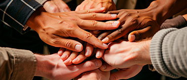 Várias mãos unidas em gesto de colaboração.