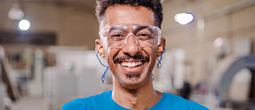 Pessoa em ambiente industrial vestindo protetor auricular.